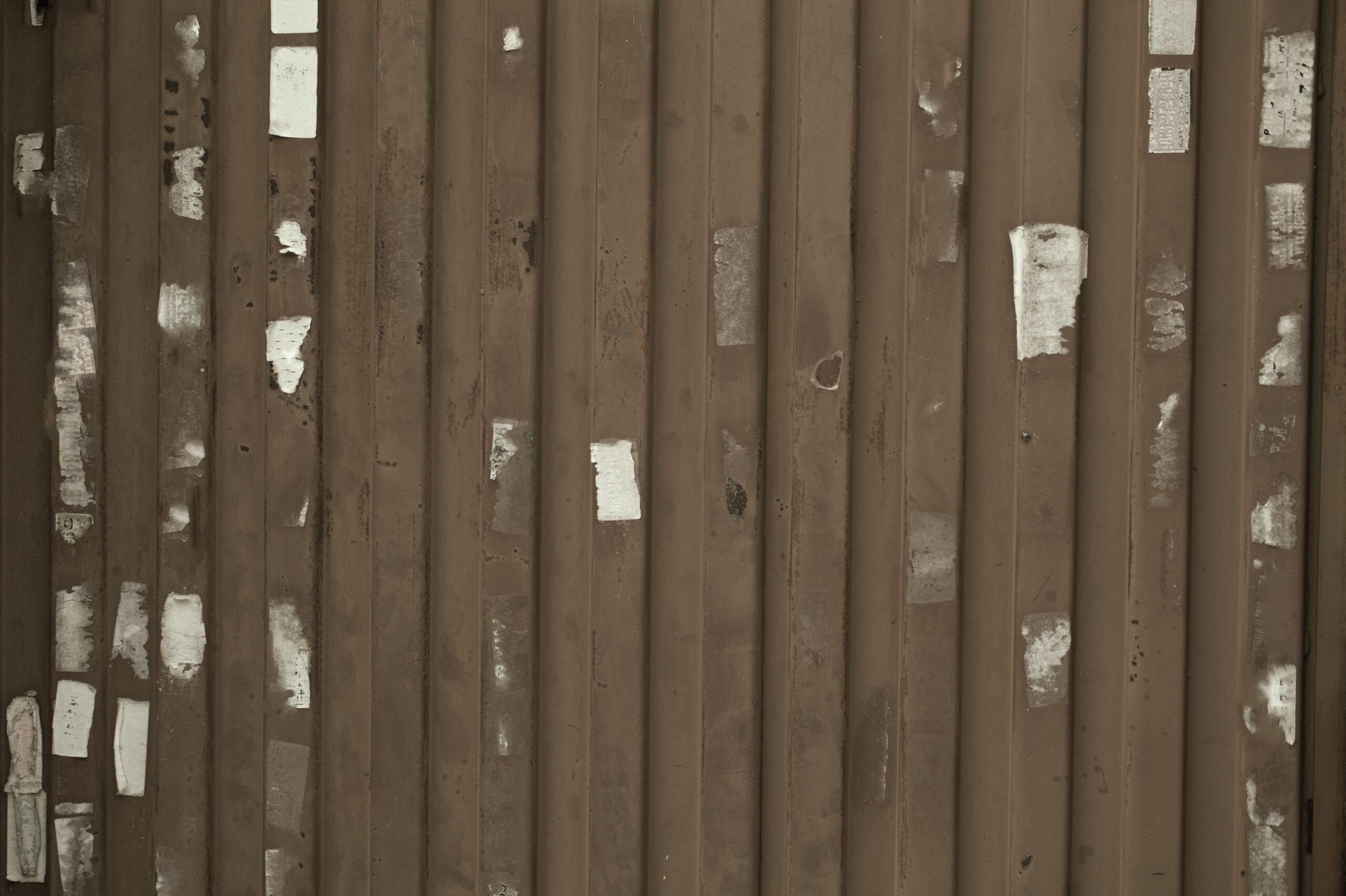 brown-corrugated-metal-with-worn-sticker-residue-2026-01-05-05-00-03-utc